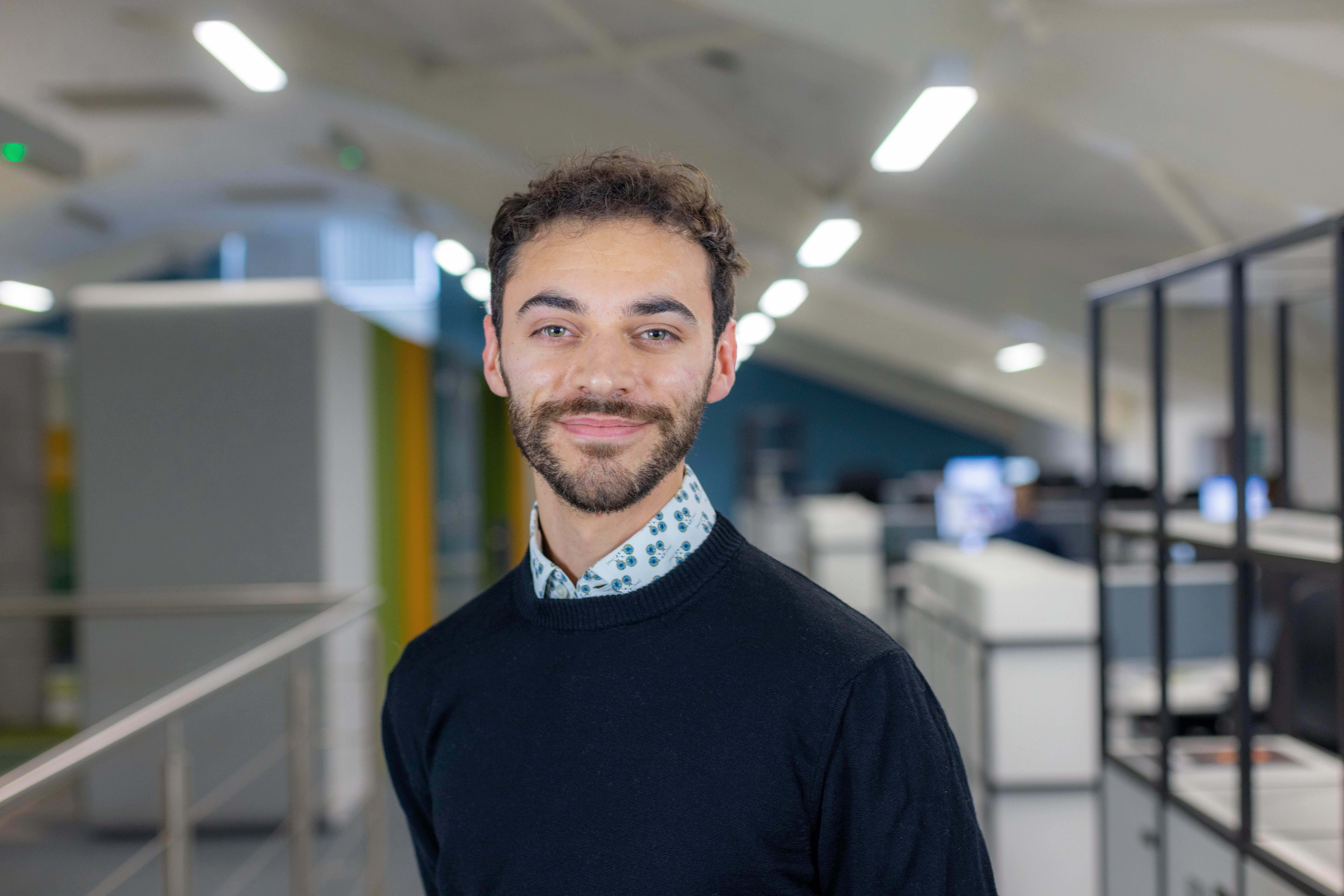 Headshot of Benjamin Gulliver, a smiling man in a navy jumper.