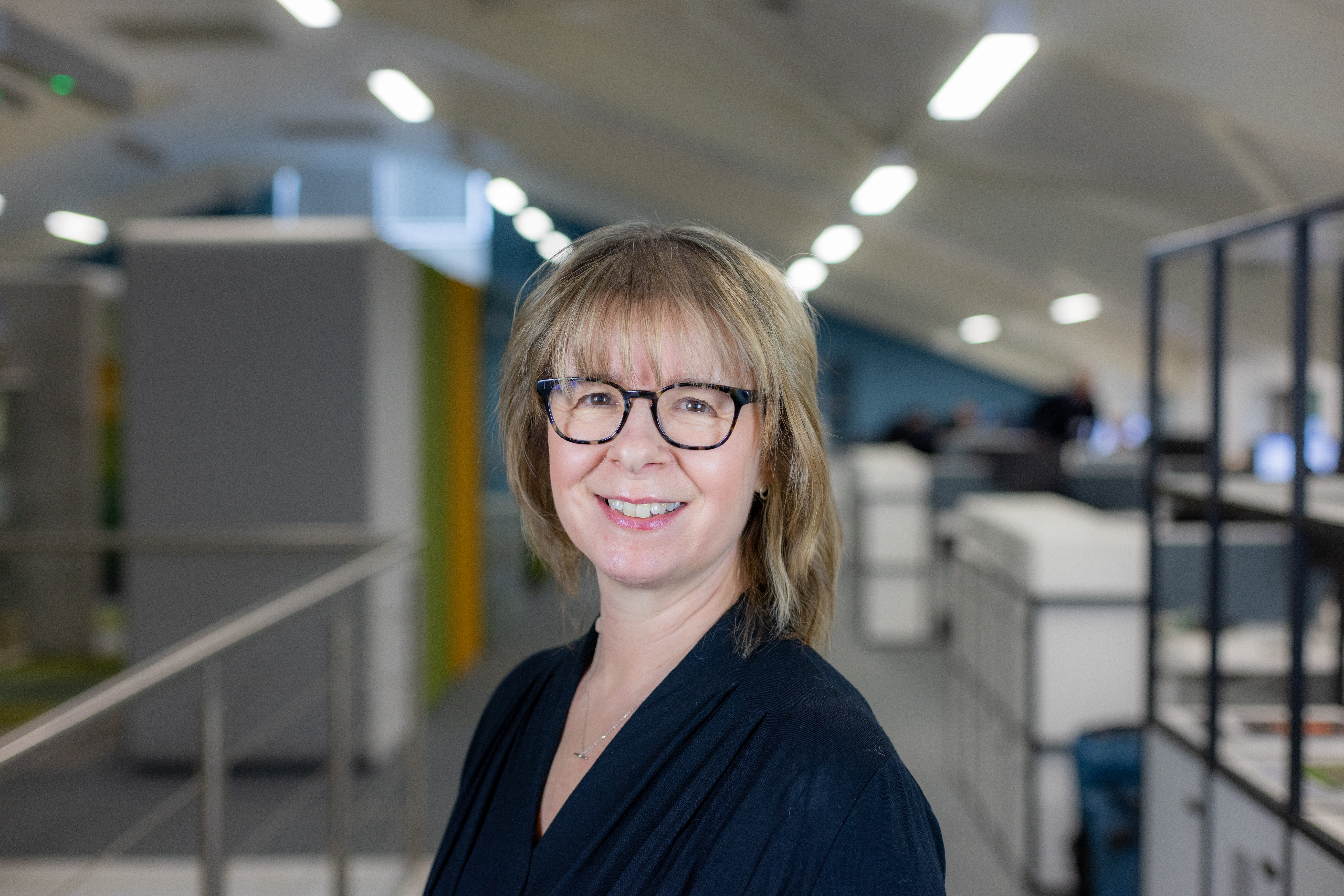 Headshot of Sally Pidgeon, a blonde woman smiling in a black top